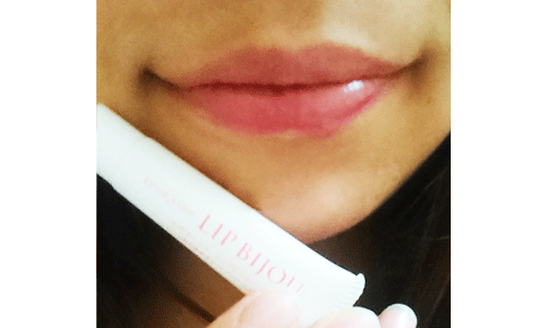 リップビジューを乾燥した唇に塗りプルプルに潤った２０代女性の唇の写真